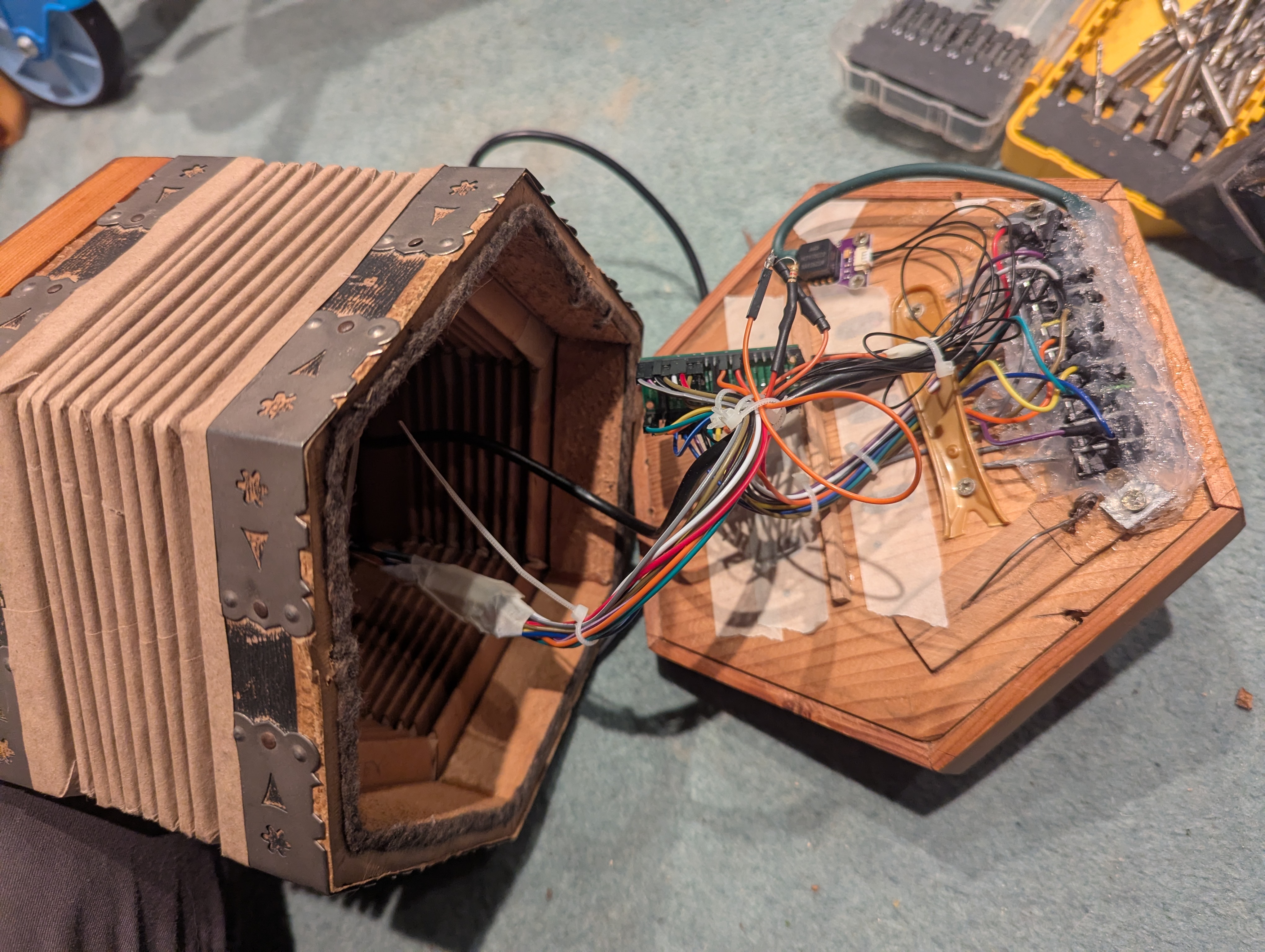 The concertina opened up, with the Pico, pressure sensor and a rather enthusiastic amount of wiring inside.