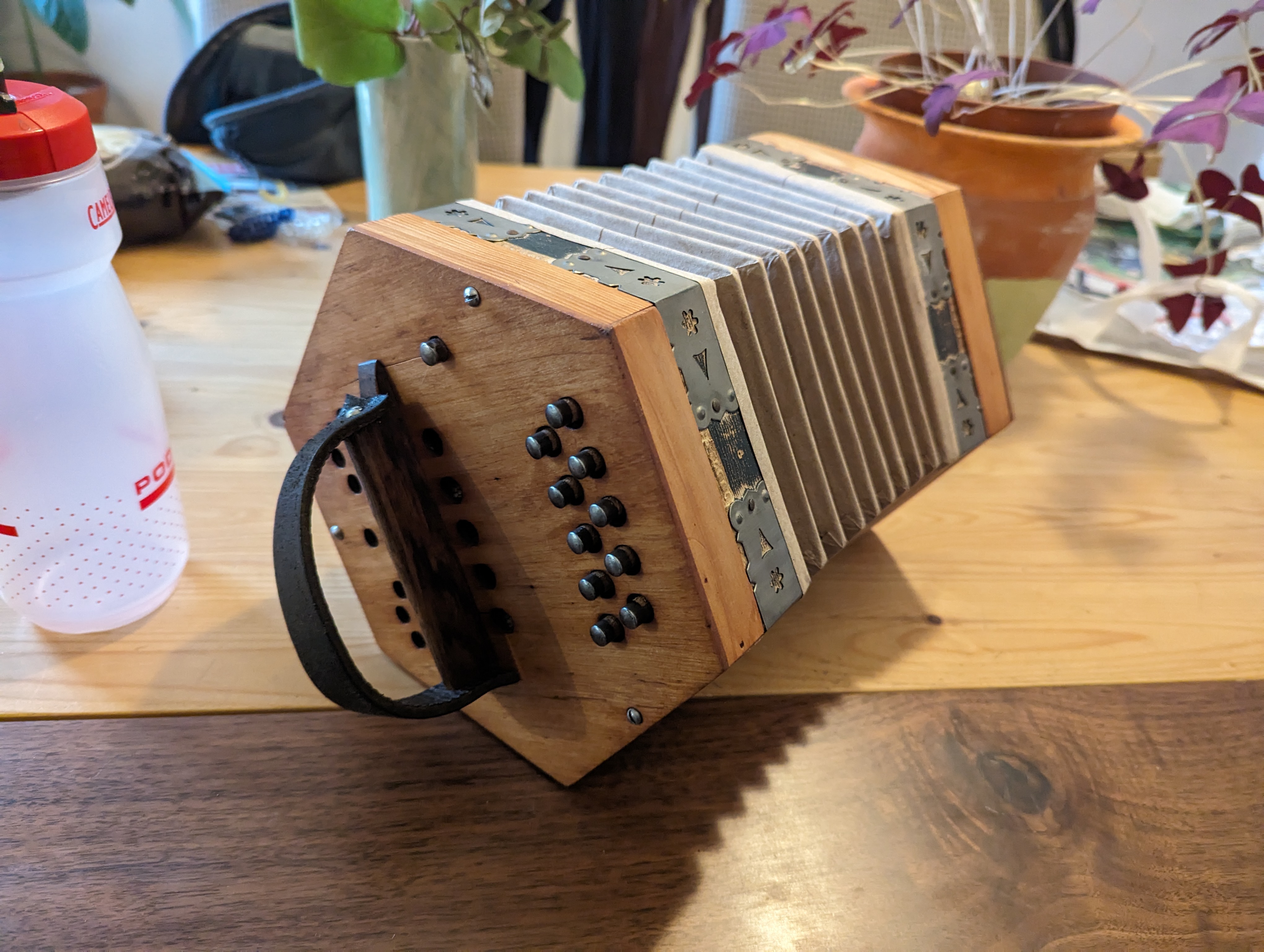 The repaired concertina, with its cleaned-up wooden body and patched bellows.